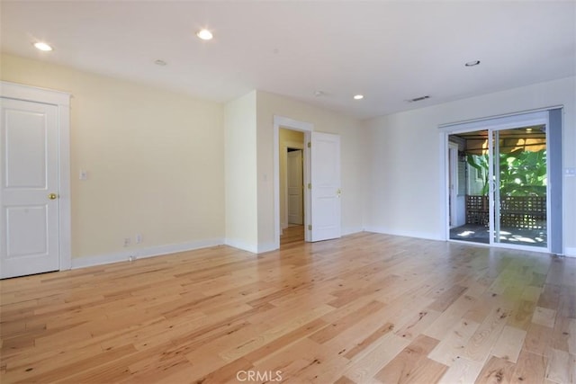 unfurnished room featuring light wood finished floors, baseboards, and visible vents