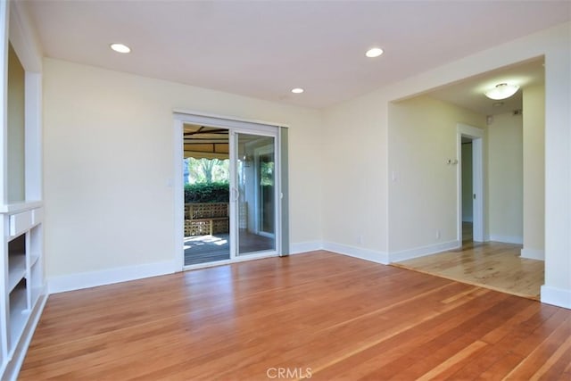 unfurnished living room featuring baseboards, light wood-type flooring, and recessed lighting