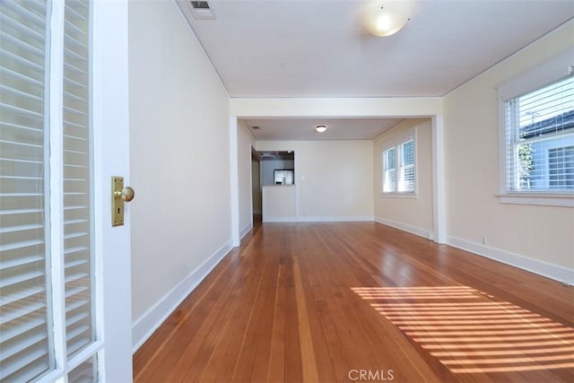 interior space featuring baseboards, hardwood / wood-style floors, and visible vents