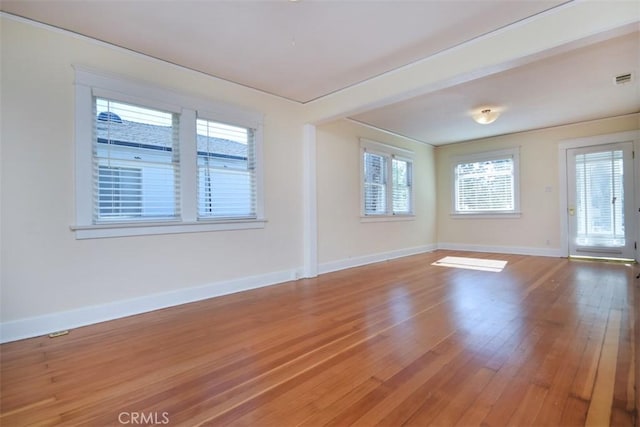 empty room with baseboards, visible vents, and light wood-style floors