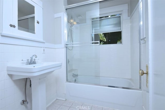 full bath featuring tile walls, tile patterned floors, and shower / bath combination with glass door