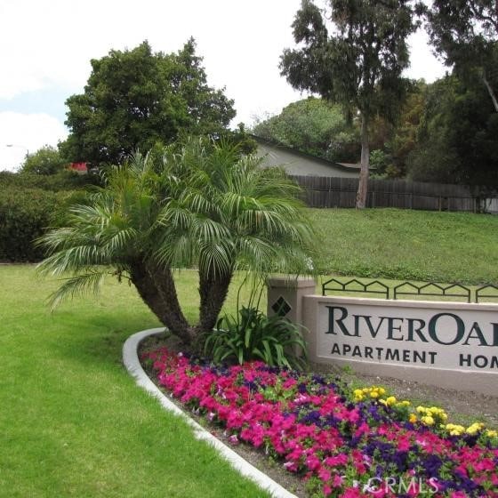 community / neighborhood sign featuring a yard and fence