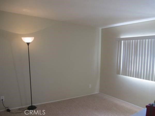 carpeted spare room featuring baseboards