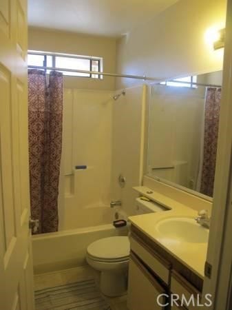 bathroom with vanity, shower / bath combo, and toilet