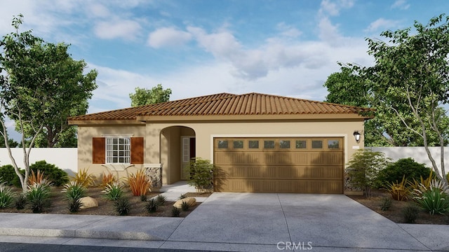 mediterranean / spanish house featuring fence, an attached garage, a tile roof, concrete driveway, and stucco siding