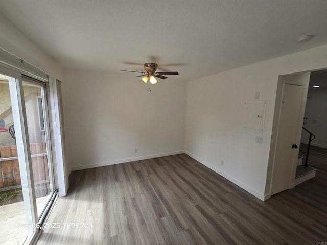 spare room featuring a wealth of natural light, wood finished floors, baseboards, and ceiling fan