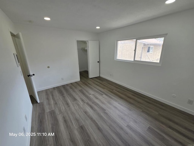 unfurnished bedroom with baseboards, a closet, recessed lighting, and wood finished floors