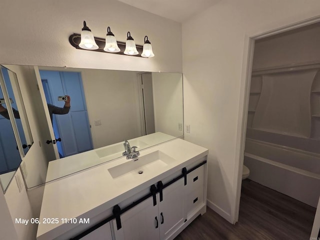 full bath featuring toilet, wood finished floors, and vanity