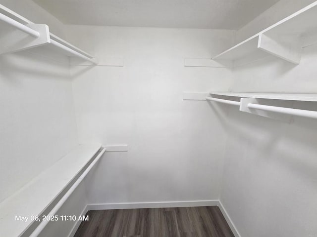 walk in closet with wood finished floors
