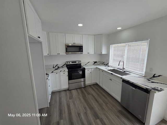 kitchen with a sink, white cabinetry, dark wood-style floors, and appliances with stainless steel finishes