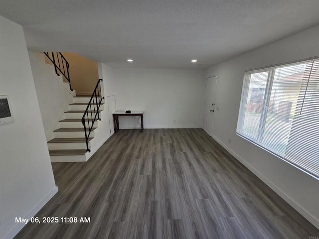 unfurnished living room featuring recessed lighting, stairway, baseboards, and dark wood-style floors
