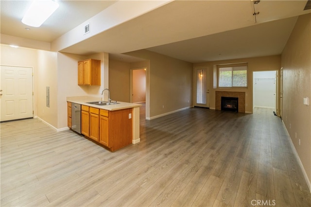 kitchen with light countertops, a sink, light wood-type flooring, visible vents, and dishwasher