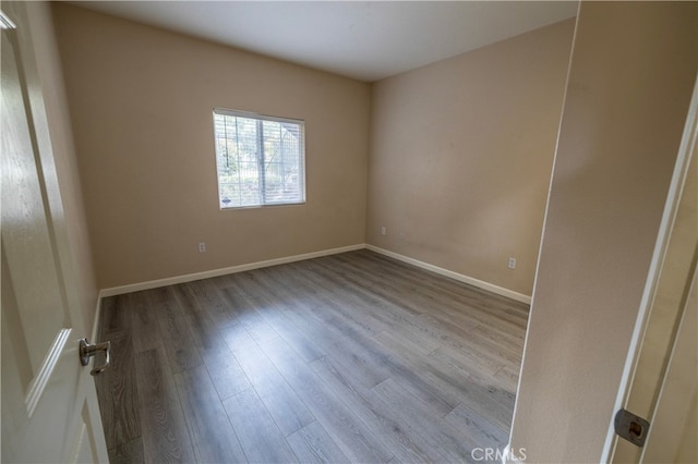 empty room with baseboards and wood finished floors