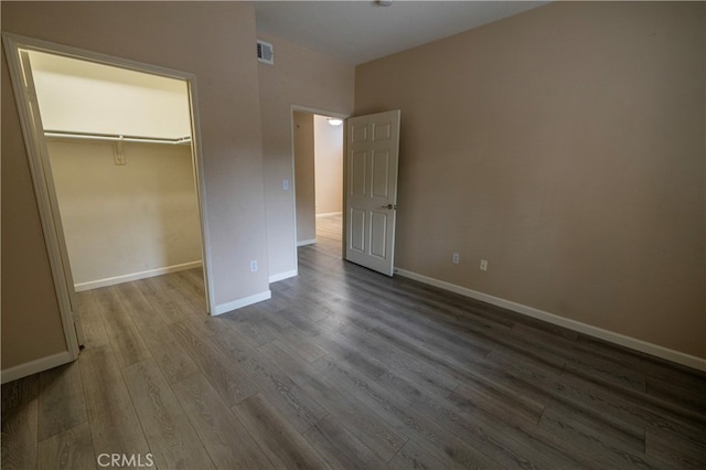 41410 Juniper St Unit 1711, Murrieta, CA 92562 - unfurnished bedroom with a closet, dark wood-type flooring, visible vents, a walk in closet, and baseboards