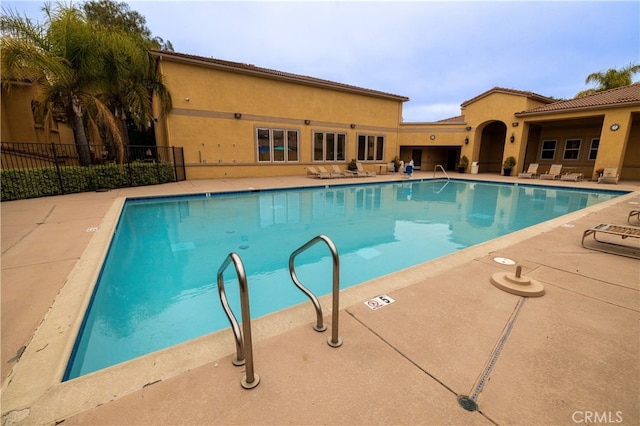 community pool featuring a patio and fence