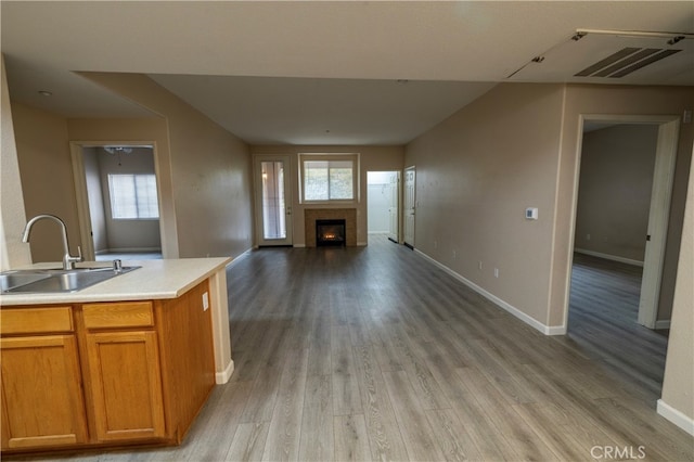 41410 Juniper St Unit 1711, Murrieta, CA 92562 - kitchen with a sink, visible vents, open floor plan, light countertops, and a tile fireplace