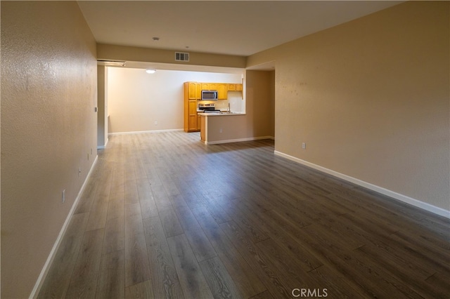 unfurnished living room featuring baseboards, visible vents, and dark wood-style floors