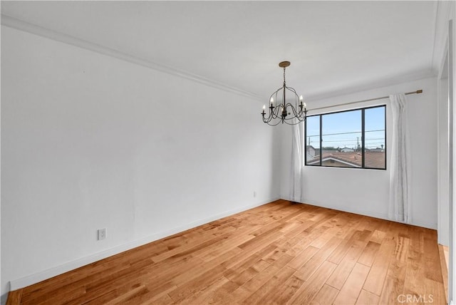spare room with light wood-type flooring, baseboards, and a notable chandelier