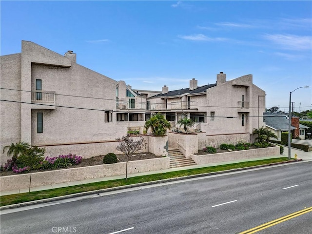 exterior space featuring stucco siding and a chimney