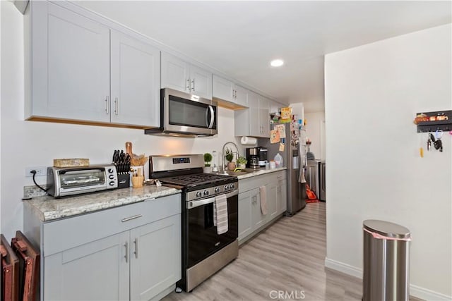 211 E Lurelane St, Rialto, CA 92376 - kitchen featuring washing machine and clothes dryer, light wood finished floors, stainless steel appliances, and a toaster