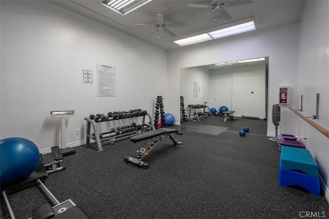 gym with a ceiling fan and baseboards