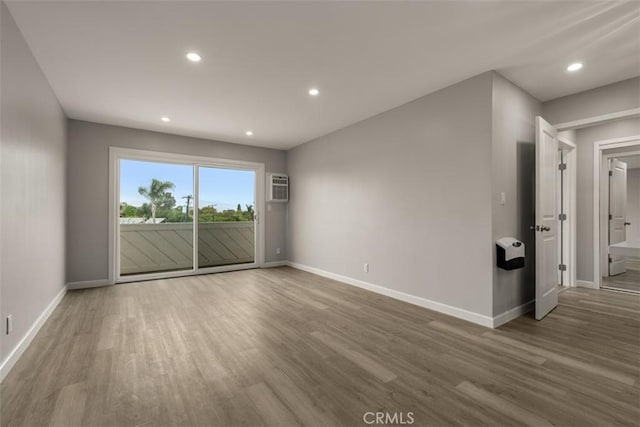 empty room featuring recessed lighting, baseboards, and wood finished floors