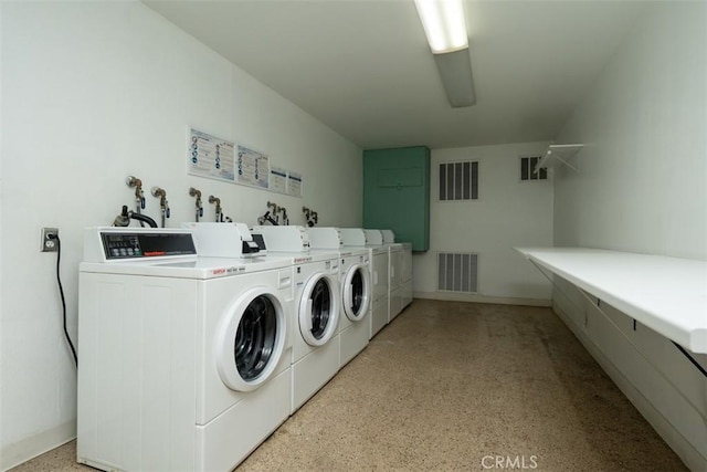 common laundry area with baseboards, washing machine and dryer, and visible vents
