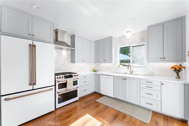 6023 Acacia Ave, Whittier, CA 90601 - kitchen with high end appliances, wall chimney exhaust hood, a sink, backsplash, and light countertops