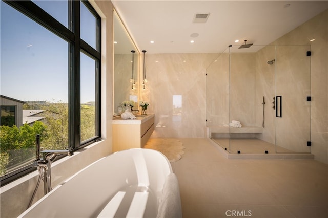 full bath featuring a stall shower, vanity, visible vents, and a freestanding tub
