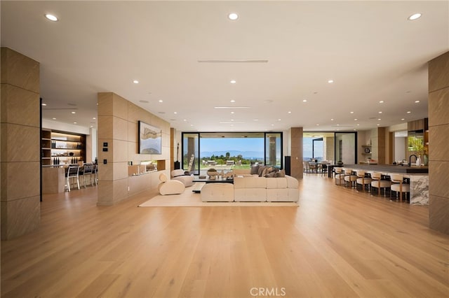 interior space with light wood-style floors, a wall of windows, and recessed lighting