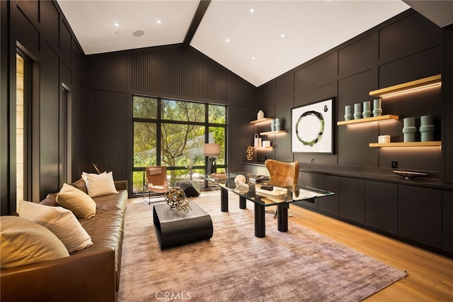 home office with vaulted ceiling, light wood finished floors, and a decorative wall