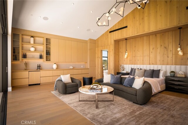 25079 Jim Bridger Rd, Hidden Hills, CA 91302 - living room with light wood finished floors, wooden walls, a notable chandelier, and high vaulted ceiling