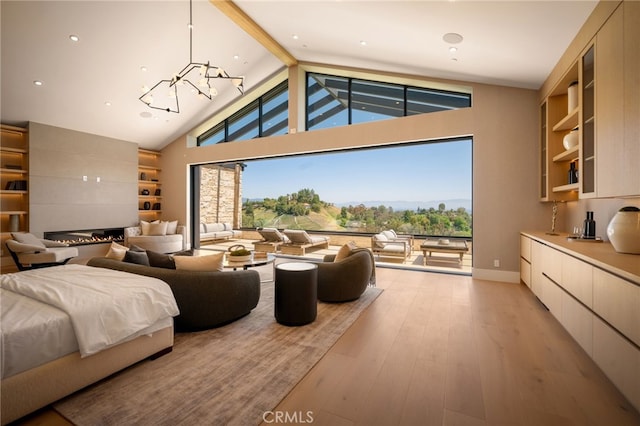 bedroom with light wood-style floors, a chandelier, access to exterior, and high vaulted ceiling
