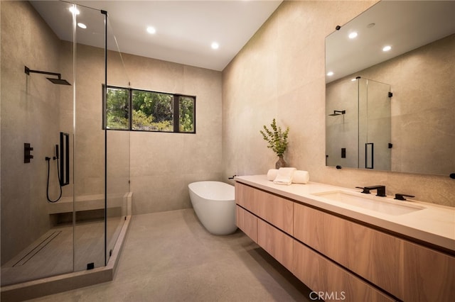 bathroom featuring a soaking tub, vanity, a shower stall, and recessed lighting