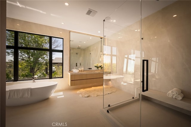 bathroom with a shower stall, visible vents, vanity, and a freestanding tub
