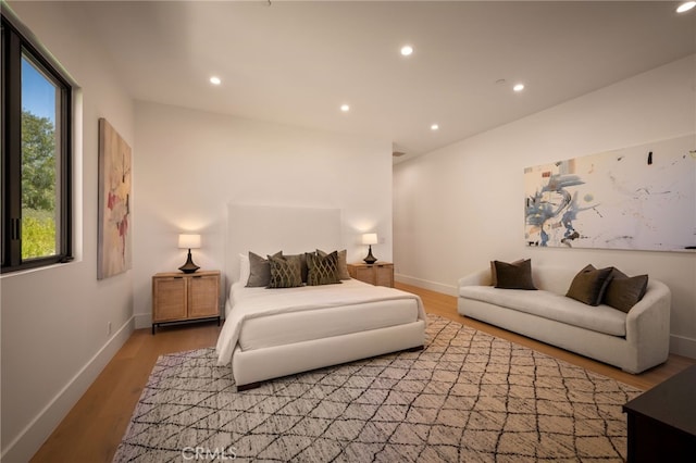 bedroom with light wood finished floors, baseboards, and recessed lighting