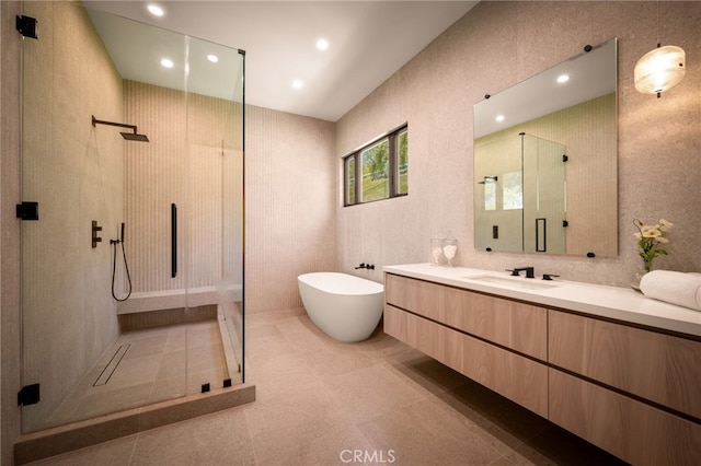 bathroom featuring a stall shower, a soaking tub, tile patterned flooring, vanity, and recessed lighting