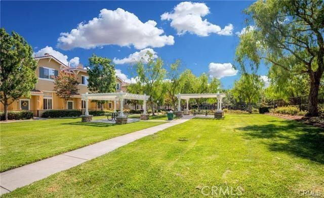 view of community featuring a lawn and a pergola