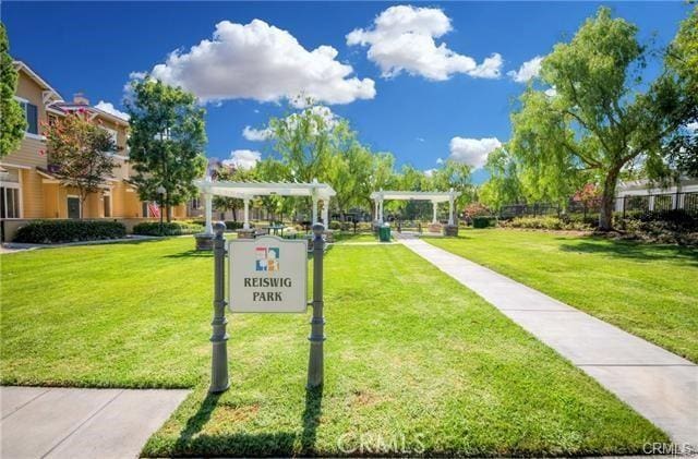view of property's community featuring a yard, a pergola, and fence