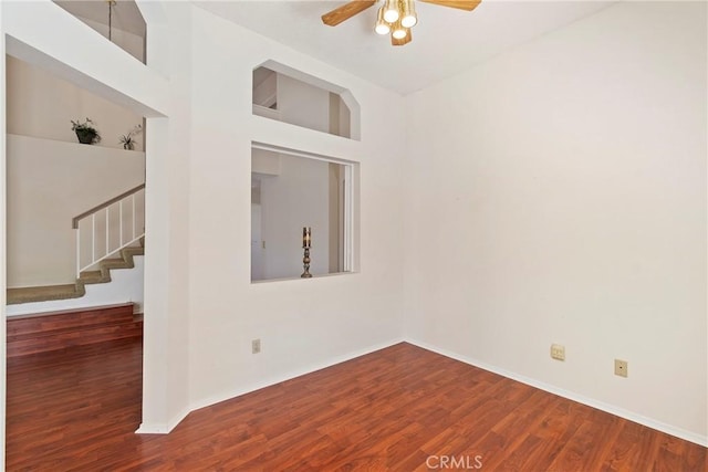 4839 W Forest Oaks Ave, Banning, CA 92220 - empty room with stairway, wood finished floors, a ceiling fan, and baseboards