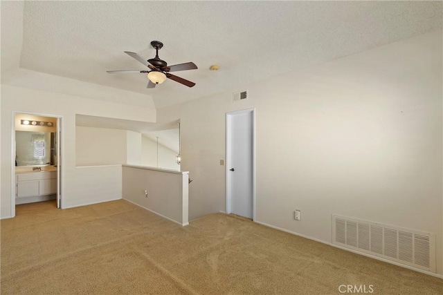 4839 W Forest Oaks Ave, Banning, CA 92220 - unfurnished bedroom featuring light carpet, connected bathroom, a ceiling fan, and a textured ceiling