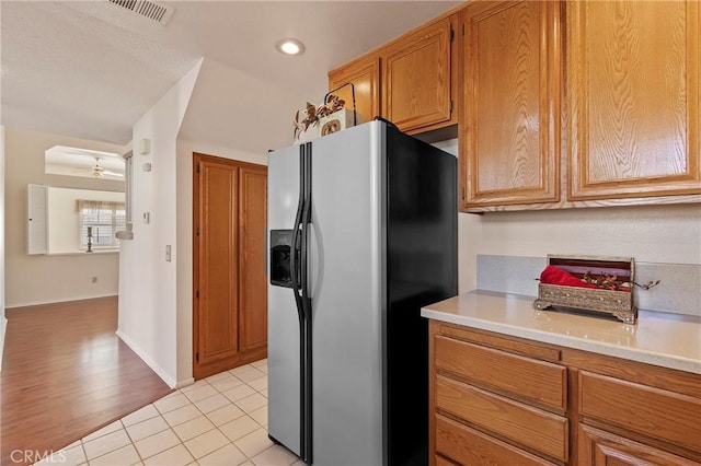 4839 W Forest Oaks Ave, Banning, CA 92220 - kitchen featuring stainless steel fridge, light countertops, brown cabinets, and baseboards