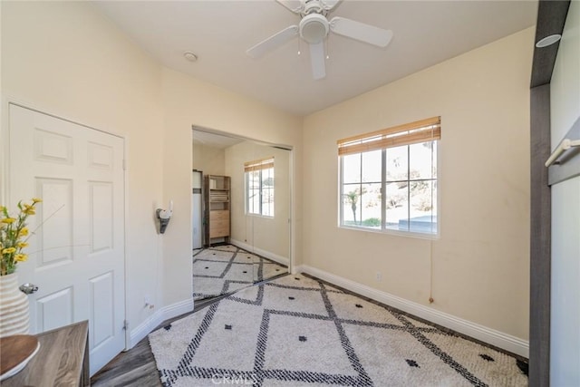 interior space with baseboards, a closet, and a ceiling fan