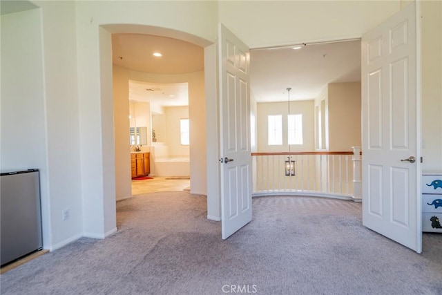 interior space featuring carpet, arched walkways, and recessed lighting