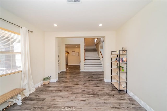 hallway featuring recessed lighting, baseboards, visible vents, stairs, and wood finished floors