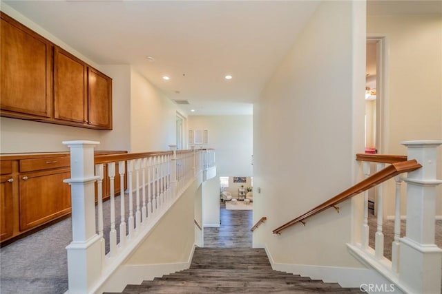 staircase featuring recessed lighting, baseboards, and wood finished floors