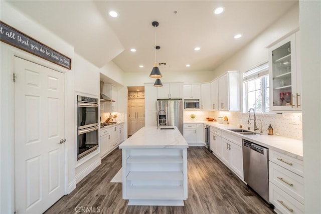 kitchen with a sink, light stone counters, white cabinetry, beverage cooler, and appliances with stainless steel finishes