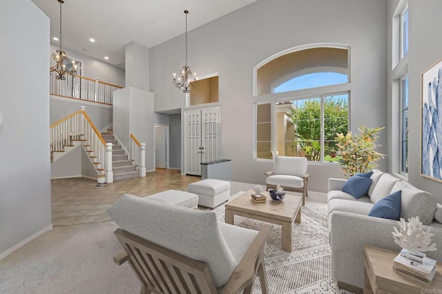 carpeted living area featuring baseboards, stairway, a chandelier, and a towering ceiling