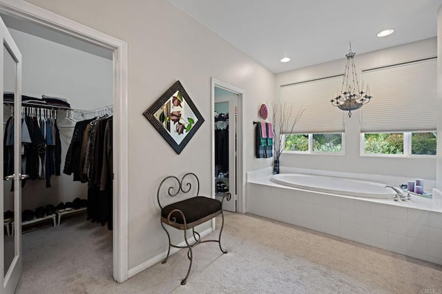 bathroom featuring recessed lighting, a spacious closet, carpet floors, a notable chandelier, and a bath