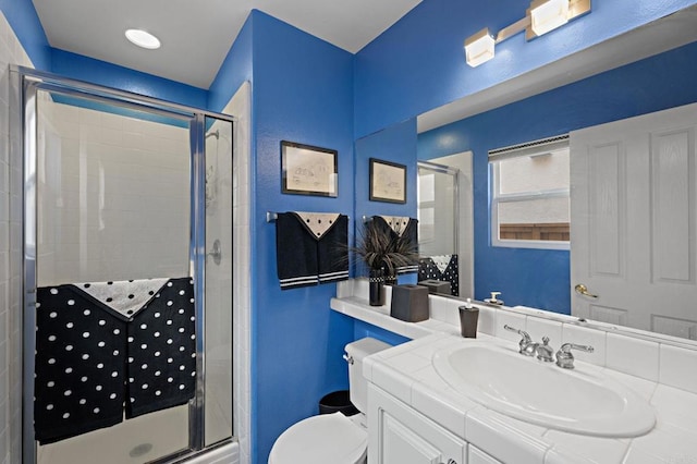 full bath with a stall shower, vanity, and toilet
